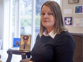 Tricia Kirkwood with her father's photo and police badge. Ottawa police constable David Kirkwood was shot and killed in the line of duty on July 11, 1977.