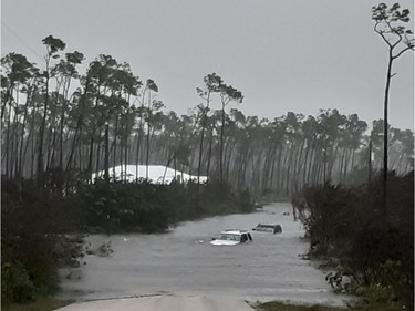 Rising waters cover cars on a road in Freeport in the Grand Bahamas on Tuesday, as hurricane Dorian passes.