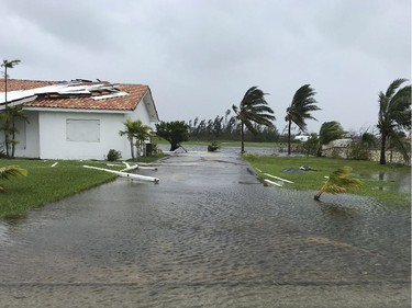 Debris is scattered on a flooded road near houses in Freeport in the Grand Bahamas on Tuesday as hurricane Dorian passes.