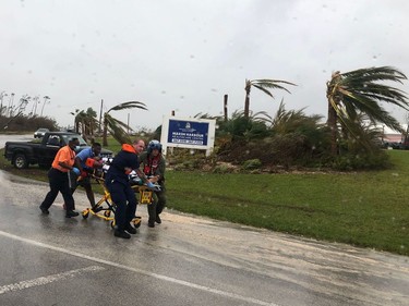 TOPSHOT - In this image courtesy of US Coast Guard (USCG), Coast Guard personnel help medevac a patient from the Marsh Harbour Healthcare Center in the Bahamas on September 3, 2019, during Hurricane Dorian. - Dorian churned towards the United States Wednesday after leaving seven dead in the Bahamas, where the prime minister said terrified residents had endured "days of horror" at the hands of the monster storm. Announcing the updated death toll, Prime Minister Hubert Minnis warned the number would rise as he called Dorian "one of the greatest national crises in our country's history."