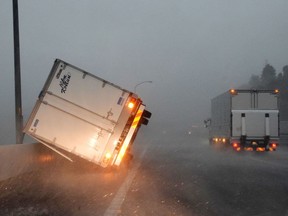 A truck turned over by high winds lies on a highway in Narita, Chiba prefecture on Monday. A powerful typhoon with potentially record winds and rain battered the Tokyo region on Monday, sparking evacuation warnings to tens of thousands, widespread blackouts and transport disruption.
