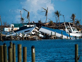 (FILES) In this file photo taken on September 11, 2019 destroyed boats are pushed up against the pier in the aftermath of Hurricane Dorian in Treasure Cay on Abaco island, Bahamas,. - Tropical Storm Humberto lashed the Bahamas with rain and wind on September 14, possibly slowing down relief efforts in the wake of the devastation wrought less than two weeks ago by Hurricane Dorian. The US National Hurricane Center said the center of the storm, packing maximum sustained winds of 60 miles (95 kilometers) per hour, was passing Saturday evening about 85 miles north of Great Abaco Island, one of the areas hardest hit by Dorian.