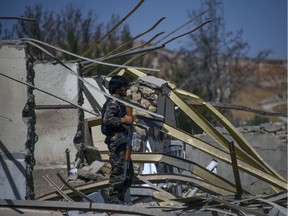 An Afghan security personnel looks on as he investigates the site where a Taliban car bomb detonated near an intelligence services building in Qalat in Zabul province on September 19, 2019.