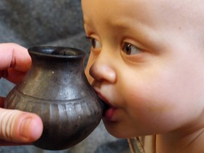 A baby is shown feeding from a reconstructed infant feeding vessel of the type investigated in research detailing prehistoric ceramic vessels that functioned as baby bottles in this image released on Sept. 25, 2019.