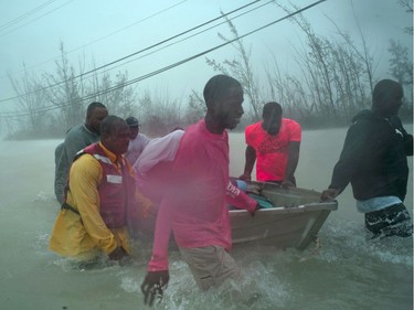 Volunteers rescue several families from the rising waters of Hurricane Dorian, near the Causarina bridge in Freeport, Grand Bahama, Bahamas, Tuesday.