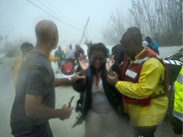 Volunteers rescue several families that arrived on small boats, from the rising waters of Hurricane Dorian, near the Causarina bridge in Freeport, Grand Bahama, Bahamas, Tuesday.