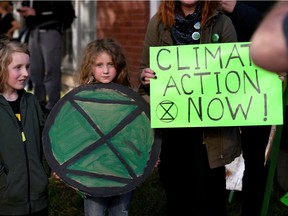 Protesters display their feelings as Liberal leader Justin Trudeau holds a Liberal party election campaign event in Edmonton on Thursday.