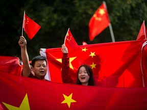 Pro-China protesters wave flags and shout at Hong Kong anti-extradition bill protesters during opposing rallies in Vancouver.