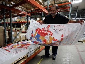 Distribution centre manager Philippe Ouellette arranges a map showing the results of the 2015 federal election at the Elections Canada distribution centre in advance of the upcoming federal election. Not all communities are well-represented come voting time.