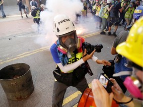 A members of media looks away from tear gas fired by police near an entrance of Causeway Bay station in Hong Kong, China, September 15, 2019. REUTERS/Amr Abdallah Dalsh ORG XMIT: GDN652