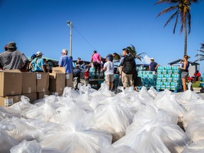 People from the Bahamas Relief Cruise, operated by the Bahamas Paradise Cruise Line, stand next to some 20,000 meals prepared for Bahamians to be delivered to distribution centers and homes in the aftermath of Hurricane Dorian and Tropical Storm Humberto in Freeport, Grand Bahama, Bahamas, on September 17, 2019.