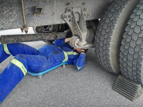 Mechanic inspects a commercial vehicle at a police safety blitz.