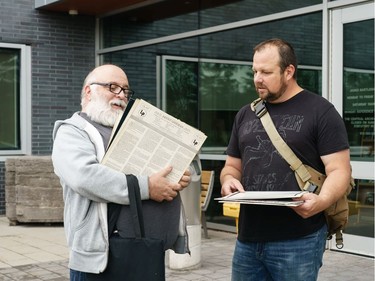 Sylvain Sarrazin (L) and Denis Charron (R) sort through the records they bought during a sell off of a record collection by the Friends of the Ottawa Public Library, at the James Bartleman Archives.