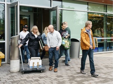 Cindy Barnes (L) and her husband Ron Gudgeon (2nd FL) bring out a dolly with a box full of records they bought during a sell off of a record collection by the Friends of the Ottawa Public Library, at the James Bartleman Archives.