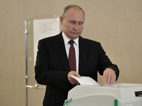 Russia's President Vladimir Putin casts his ballot at a polling station during the Moscow city parliament election in Moscow, Russia on Sunday.