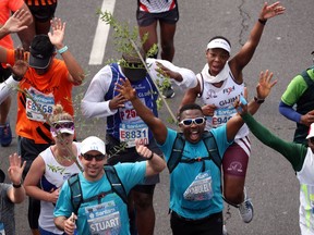 Activist and treegrower Siyabulela Sokomani celebrates as he approaches the final stretch of the Cape Town marathon, in South Africa September 15, 2019. He is one of a group of 20 runners participating in the marathon with saplings on their backs to promote the planting of native trees amid a nationwide push to replace invasive species with indigenous ones to cope with drought and climate change.