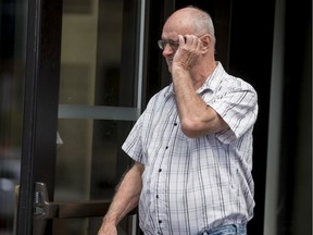 Former Scout leader Donald Joseph Sullivan tires to cover his face as he leaves the Ottawa courthouse in August 2019.
