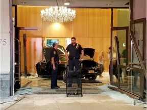 Police officers stand near a car after it crashed into the lobby of the Trump Plaza in New Rochelle, New York, U.S., September 17, 2019, in this still image from video obtained via social media.