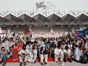 Members of Venice's "No Big Ships" Committee (No Grandi Navi) and people stage a protest against the cruise ships that sail in the Venice lagoon, and against the TurinLyon high-speed railway project (No TAV) on Sept. 7 , 2019 on the red carpet access outside the Festival Palace (Palazzo del Cinema) during the 76th Venice Film Festival at Venice Lido.