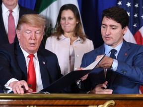 US President Donald Trump and Canadian Prime Minister Justin Trudeau changes documents after signing a new free trade agreement in Buenos Aires, on November 30, 2018, on the sidelines of the G20 Leaders' Summit.