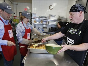 Jim Sofia, left, Monica Pecek, centre, and Alain David, right, prepare an Easter lunch at the Shepherds of Good Hope in Ottawa on Sunday, April 1, 2018.