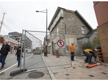 Workers remove the sidewalk barricade in front of Magee House on Wellington St.  after engineers deemed the building safe following repairs to the structure of the heritage building.