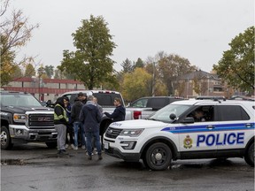 An Ottawa Police officer talks with a small gathering of tow truck operators in a parking lot near Brewer Park. A planned  protest or blockade of highway 417 at rush hour was averted by negotiations with the Ontario Provincial Police.