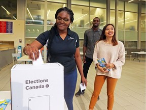 Dee Kolade of Nigeria participates in a mock vote at Carleton University as Delcio Manuel (M) and Mallyna Hing (R) look on, October 01, 2019.