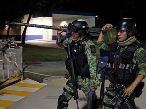 Soldiers carry a weapon and ammo after arriving at the Culiacan international airport a day after cartel gunmen clashed with federal forces, resulting in the release of Ovidio Guzman from detention, the son of drug kingpin Joaquin "El Chapo" Guzman, in Culiacan, in Sinaloa state, Mexico October 18, 2019. REUTERS/Stringer