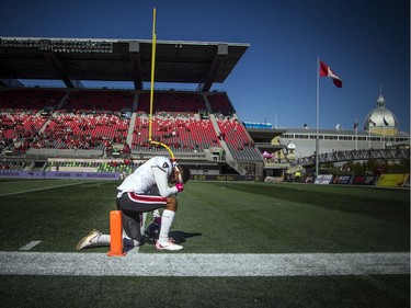 Ravens #87 Chad Manchulenko kneels to pray before the game began.