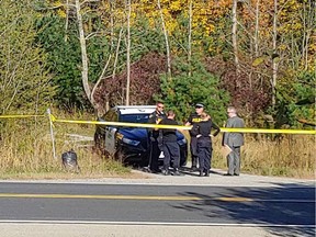 Police vehicles and officers can be seen outside a home on County Road 5 in the small community of Caintown, Ont., near Mallorytown, on Friday.