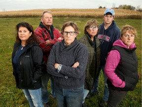 Ace Powell, in red jacket, and his wife, Michelle,far left, along with their neighbours — from left, Teddie Laframboise, Pat Gillis, Austin Hutt and Casey Gillis, stand at the end of Powell's property in North Gower, where a massive warehouse/distribution centre is proposed.