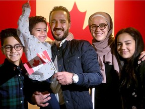 Anas Alargha Almasri, 39, couldn't stop smiling all the way through his citizenship ceremony with children Lilyan, 13, Tarek, 12, and Yousef, 5, on Friday. His wife, Eman Awad, 30,has to wait a little longer for her citizenship.