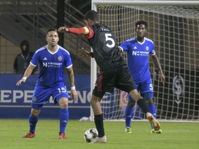 Charlotte's Ricardo Bocanegra (15) and Steven Thicot keep a close watch on Ottawa's Wal Fall during Saturday night's match.