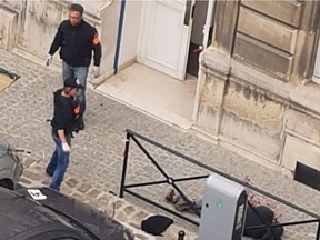 A picture obtained on October 5, 2019 shows two police members past the body of Mickael Harpon, 45-year-old computer expert, shot dead by a policeman after he stabbed four colleagues to death in a frenzied attack at Paris police headquarters in Paris on October 3, 2019. - Three police officers and an administrative worker -- three men and one woman -- died in the lunchtime attack on October 3, 2019 at the police headquarters, in the historic heart of Paris. Preliminary enquiries suggest that the attacker, a convert to Islam, could have become radicalised, said sources, who added that he had worked in a section of the police service dedicated to collecting information on jihadist radicalisation.