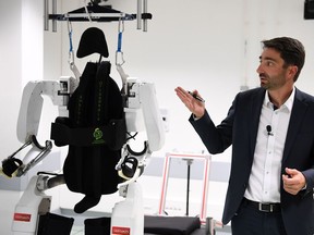 French project manager Gullaume Charvet presents the brain-controlled exoskeleton that allowed a disabled patient to walk again at the biomedical research center Clinatec in Grenoble on October 7, 2019. - A French man paralysed in a night club accident can walk again thanks to a brain-controlled exoskeleton in what scientists said was a breakthrough providing hope to tetraplegics seeking to regain movement. The patient trained for months, harnessing his brain signals to control a computer-simulated avatar to perform basic movements before using the robot device to walk. Doctors who conducted the trial cautioned that the device is years away from being publicly available but stressed that it had "the potential to improve patients' quality of life and autonomy"