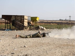 A Turkish-backed Syrian fighter fires towards the border town of Ras al-Ain on October 13, 2019, as Turkey and it's allies continued their assault on Kurdish-held border towns in northeastern Syria. - Turkish forces and their proxies pushed deep into Syria Sunday, moving closer to completing their assault's initial phase, while Washington announced it was pulling out 1,000 troops from the country's north. (Photo by Nazeer Al-khatib / AFP)