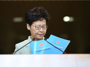 Hong Kong Chief Executive Carrie Lam displays copies of her 2019 policy address a day before presenting it to the public as she takes part in her weekly press conference in Hong Kong on Tuesday.