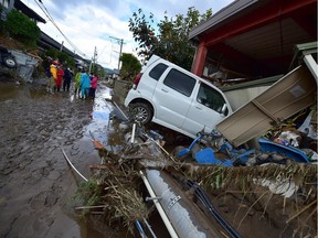 A car sits next to a badly damaged home in Nagano on Tuesday after Typhoon Hagibis hit Japan on Saturday.