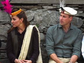 Britain's Prince William (R), Duke of Cambridge watches a traditional Kalash dance as his wife Catherine (C), Duchess of Cambridge, talks with a member of the Kalash tribe during their visit to the Bumburate Valley in Pakistan northern Chitral District on October 16, 2019. - Prince William and his wife Kate flew near the Afghan border to visit a remote Hindu Kush glacier on October 16, after a morning spent trying on feathered traditional caps and luxurious shawls in Pakistan's mountainous north.