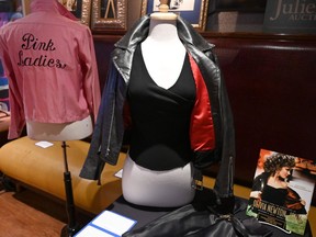 Olivia Newton-John's famous black leather jacket worn in the blockbuster film "Grease" and her Grease "Pink Ladies" jacket worn in the film are shown during a Julien's Auctions press preview at Hard Rock Cafe in New York on October 16, 2019. - Over 500 of the most iconic film and television worn costumes, ensembles, gowns, personal items and accessories owned and used by the four-time Grammy award-winning singer/Hollywood film star and the proceeeds will benefit the Olivia Newton-John Cancer Wellness & Research Centre. (Photo by TIMOTHY A. CLARY / AFP)