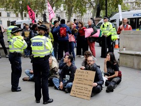 Police monitor as climate activists protest in London on Thursday.