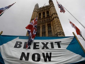Pro-Brexiteers hold a banner near the Houses of Parliament in Westminster, central London on October 17, 2019.