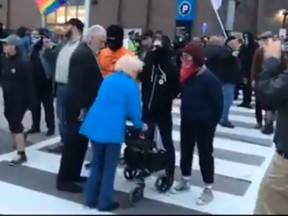 Masked protesters block elderly woman from getting across the street to see Maxime Bernier's Event at Mohawk College, in Hamilton.