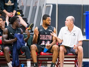 Dave Smart provides in-game coaching to Lloyd Pandi during a preseason game of the Carleton Ravens university men's basketball team in August 2019.