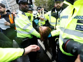 A protester is detained after he was taken off the scaffolding during Extinction Rebellion demonstration at Trafalgar Square, London, Britain October 7, 2019.