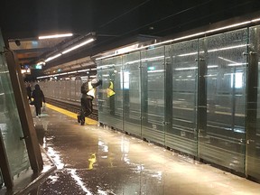 Riders huddle for shelter as rain pours into Hurdman LRT Station Thursday.