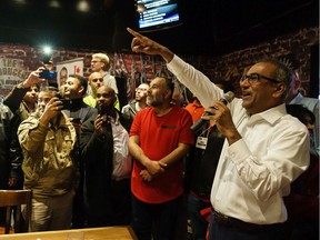 Chandra Arya, right, celebrates his electoral win with supporters in the riding of Nepean at Broadway Bar & Grill on Monday night.