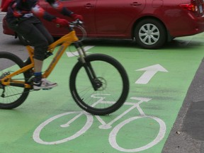 Bikes and cars on the O'Connor Street bike lane in Ottawa. The Official Plan's goals include several ideas for reducing car use.