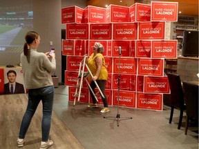 Campaign worker Nathalie Montpetit gets her photo taken in front of some Orleans Liberal candidate Marie-France Lalonde signs before the polls close in Ottawa Monday Oct 21, 2019.